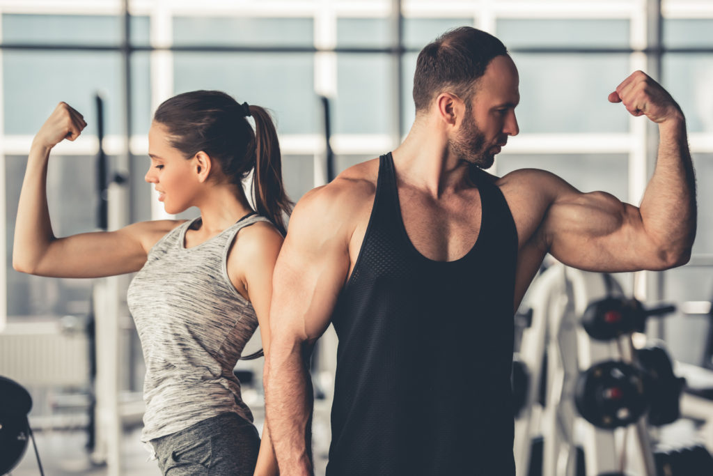 Beautiful sports couple is showing their muscles.