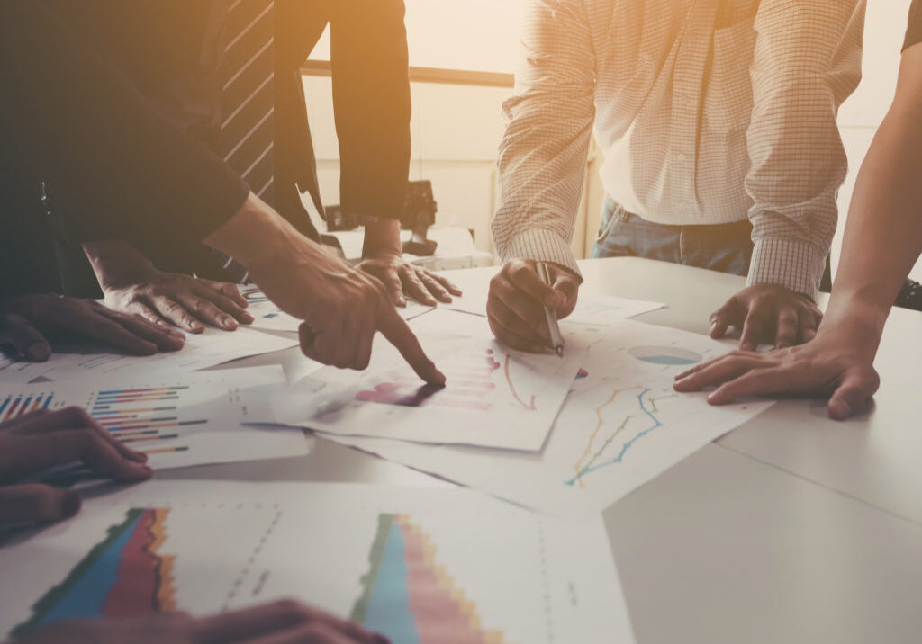 Group of businessman meeting analyze the company performance and growth corporate with information data paper.